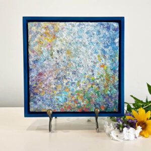 Available, July 2025. An abstract painting in a blue frame with flowers.